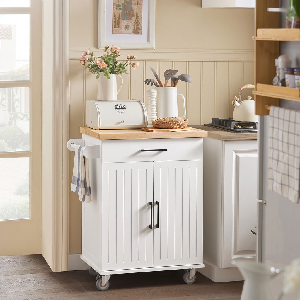 A white kitchen cart with a wooden top is shown in a kitchen setting, next to a doorway and a stove.