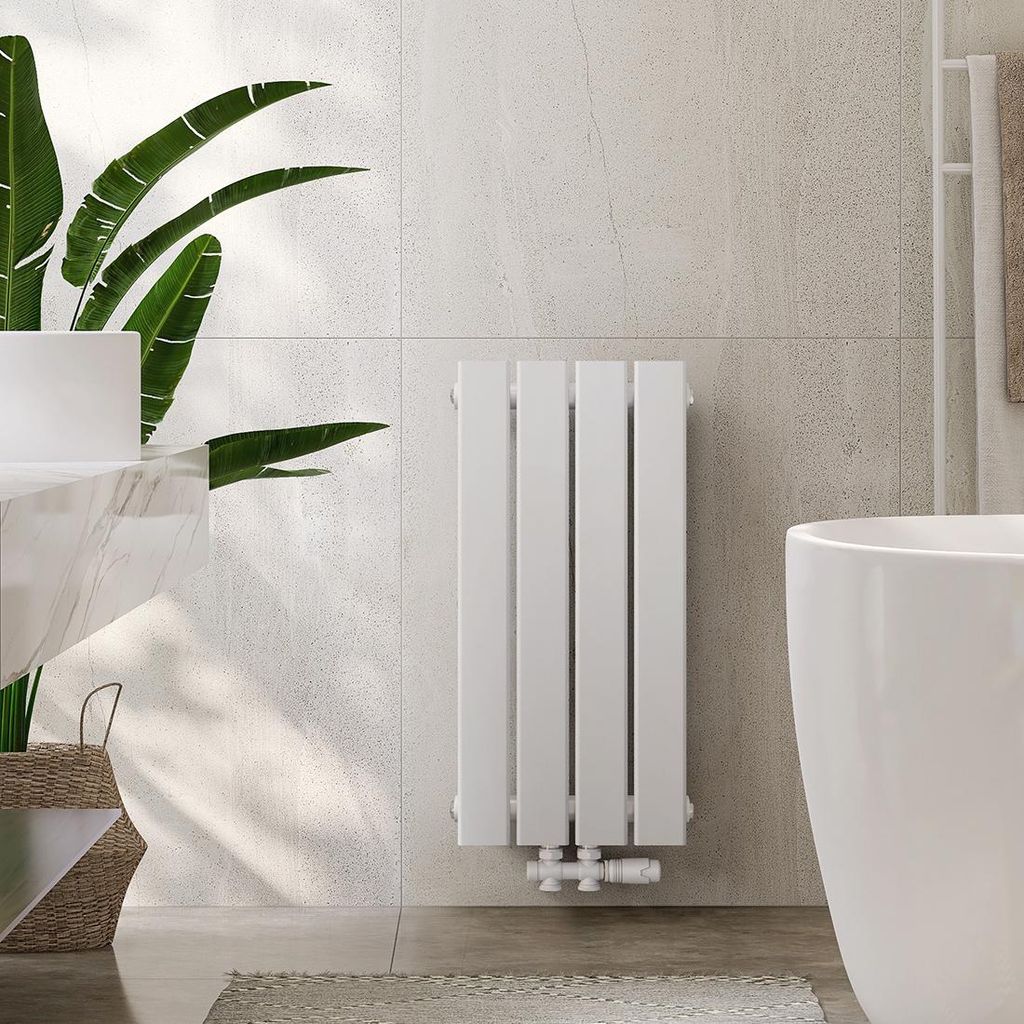 A modern bathroom with a white vertical radiator, a large plant, and a bathtub.