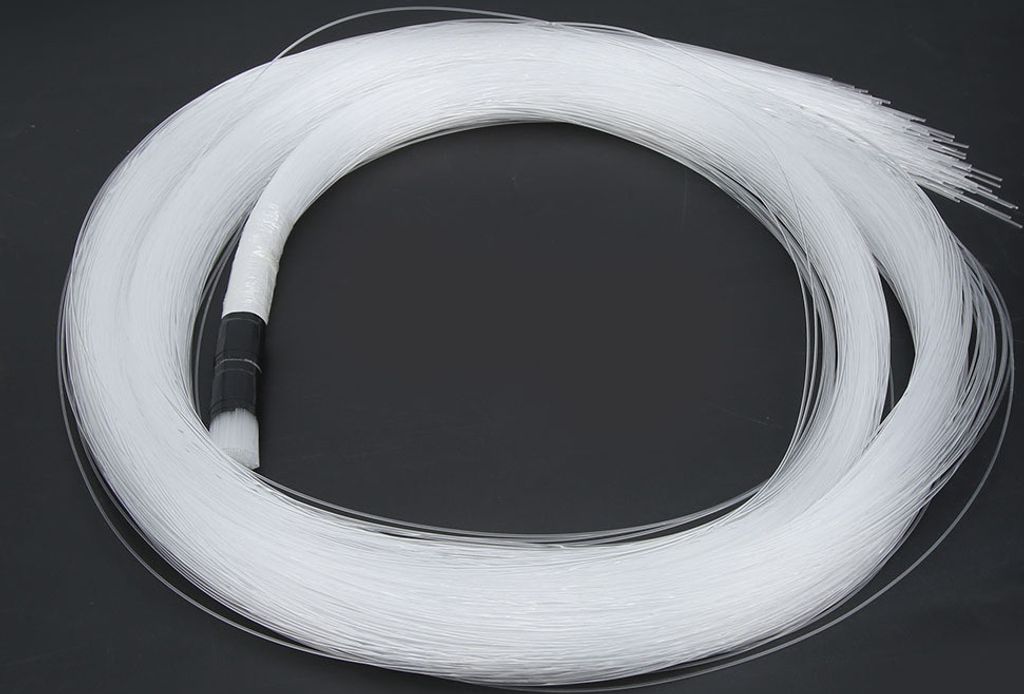 A coiled bundle of white fiber optic cables on a black background.