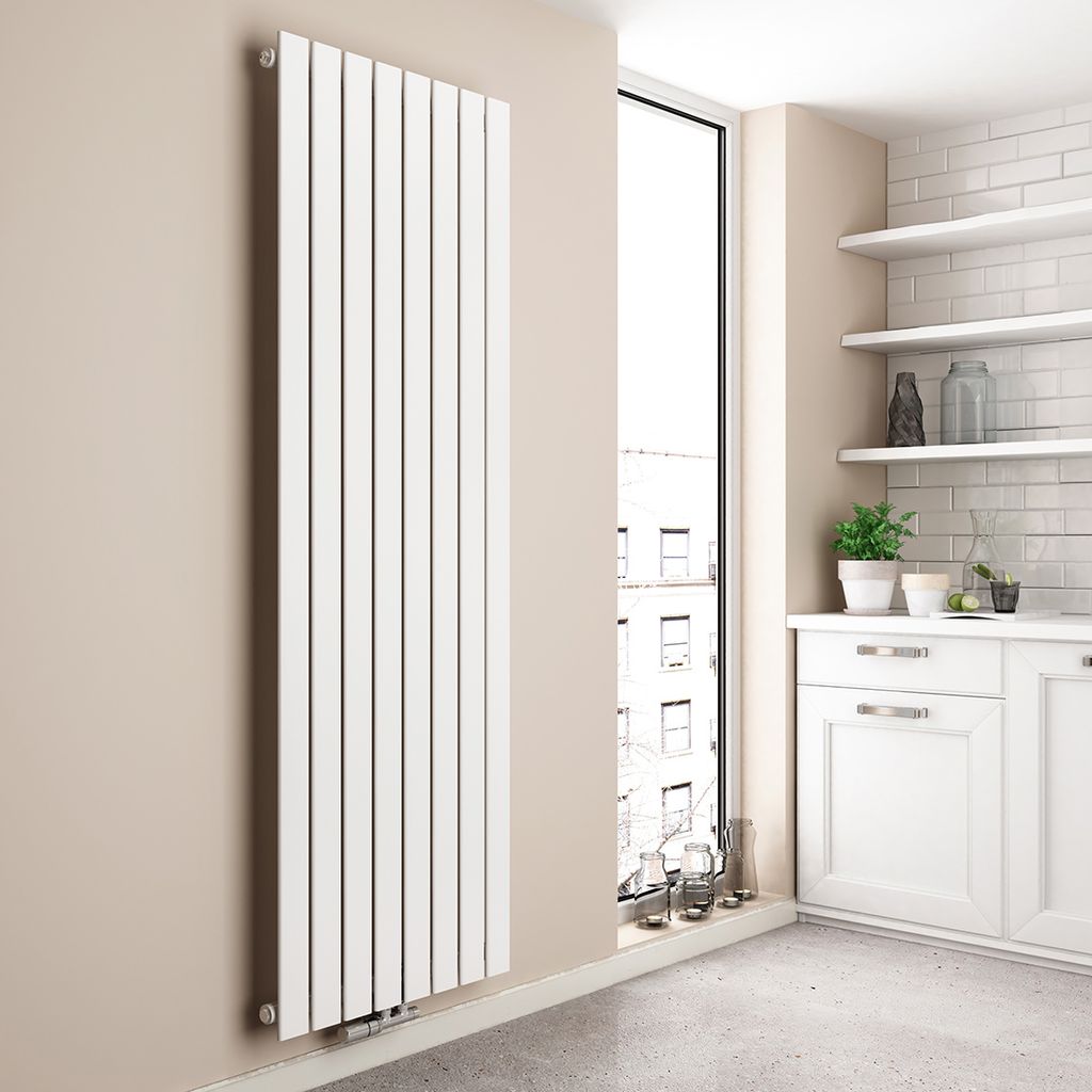 A vertical designer radiator is shown in a modern kitchen setting, next to a large window.
