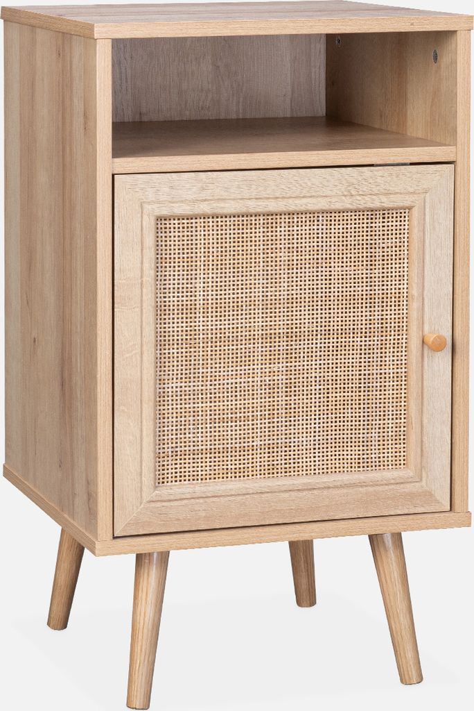 A wooden nightstand with a rattan woven door and a shelf above, standing on four tapered legs.