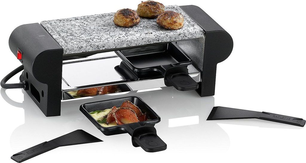 A raclette grill with a stone cooking surface and two small pans underneath.