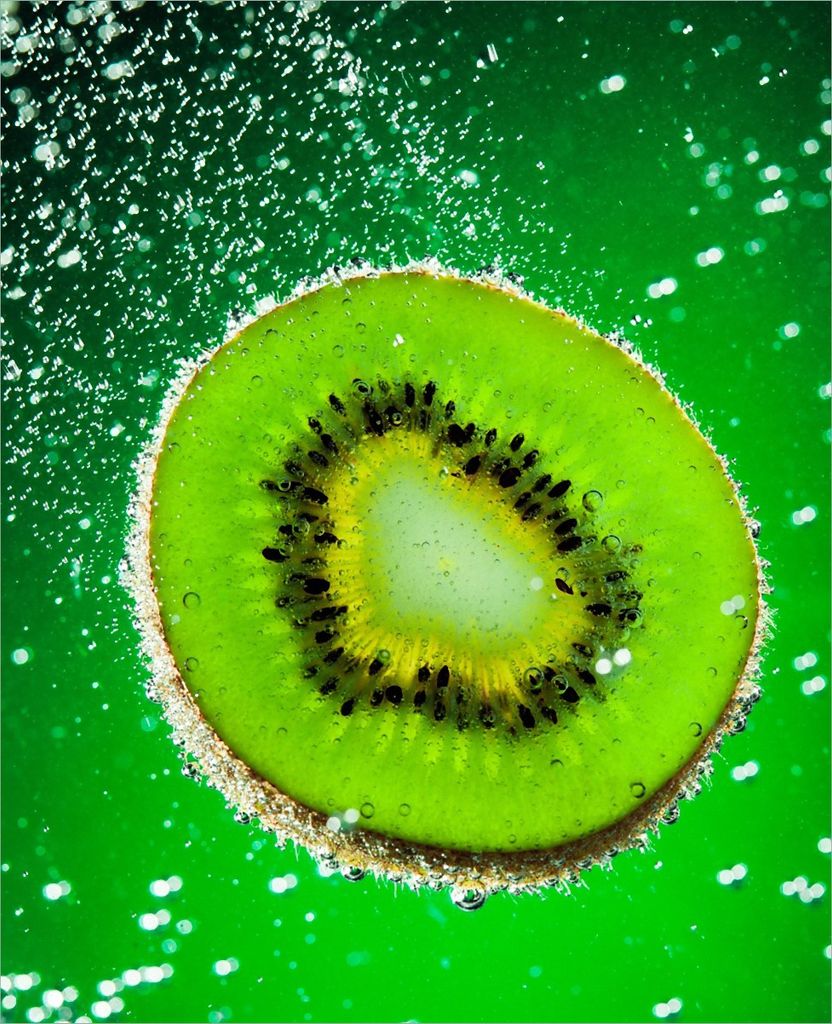 Wallario Magnet für Kühlschrank / Geschirrspüler, magnetisch haftende Folie - 60 x 80 cm, Motiv: Grüne Kiwi-Scheibe im Wasser