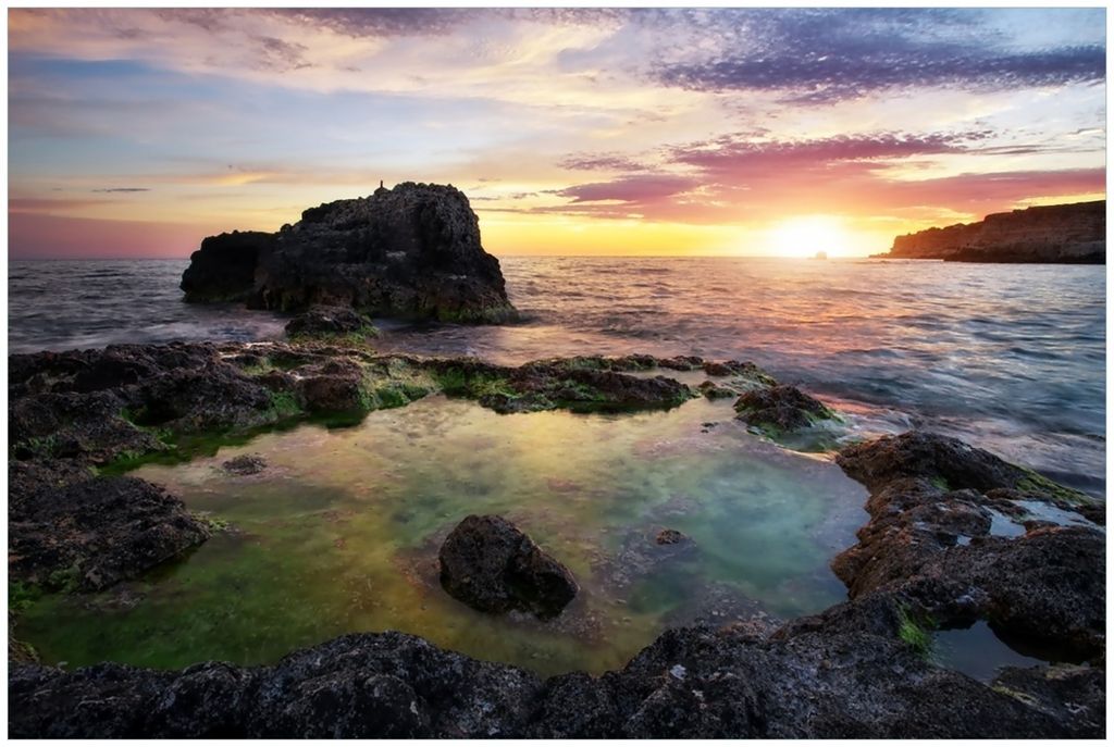 Wallario Premium Glasbild, freischwebende Optik, kräftige Farben, Größe 90 x 60 cm Motiv Felsige Küste bei Sonnenuntergang