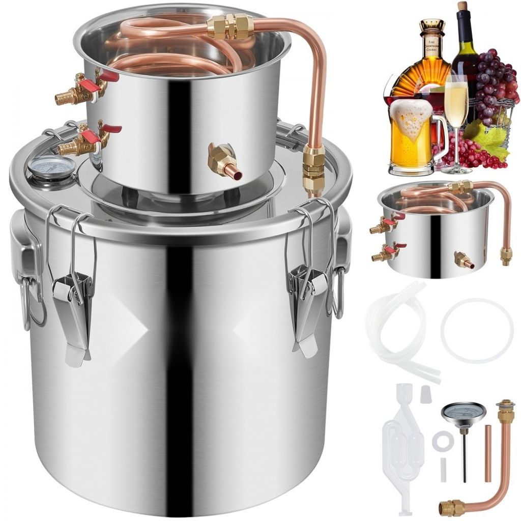 A stainless steel distiller with various accessories and beverages in the background.