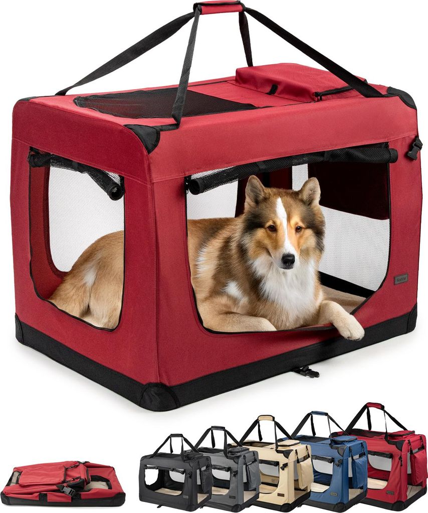 A dog is inside a red dog carrier. Below the carrier are several other dog carriers in different colors and a folded carrier.