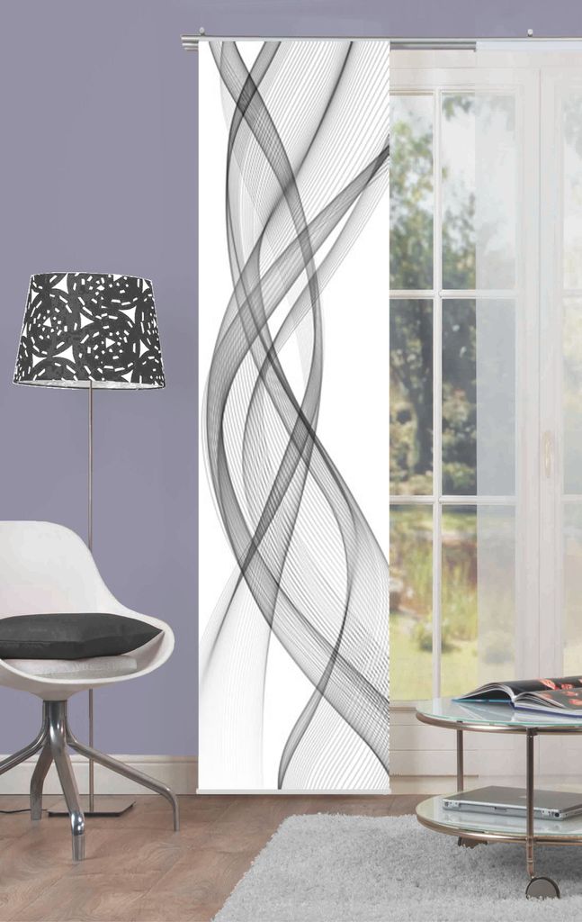 A modern living room scene with a floor lamp, a chair, a coffee table, and a sliding panel curtain with a graphic design.