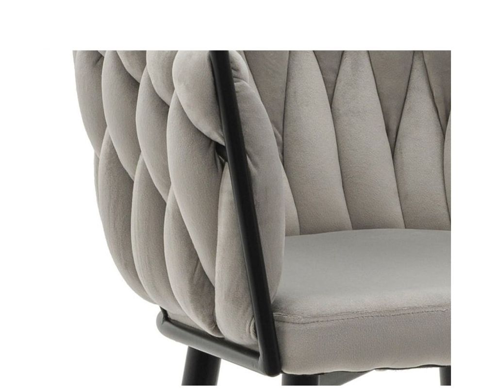 Close-up of a light grey upholstered chair with a black metal frame.