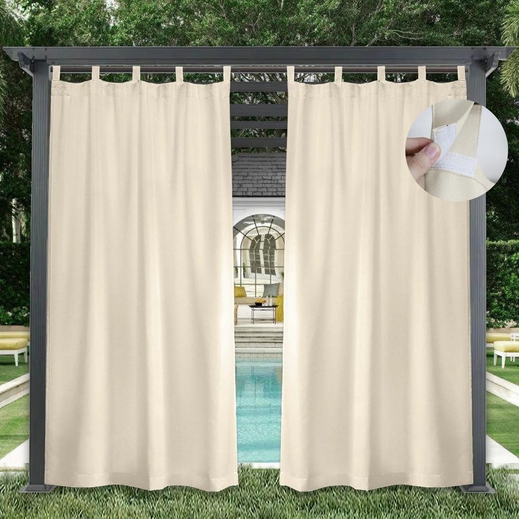 Outdoor curtains hanging on a pergola next to a swimming pool.