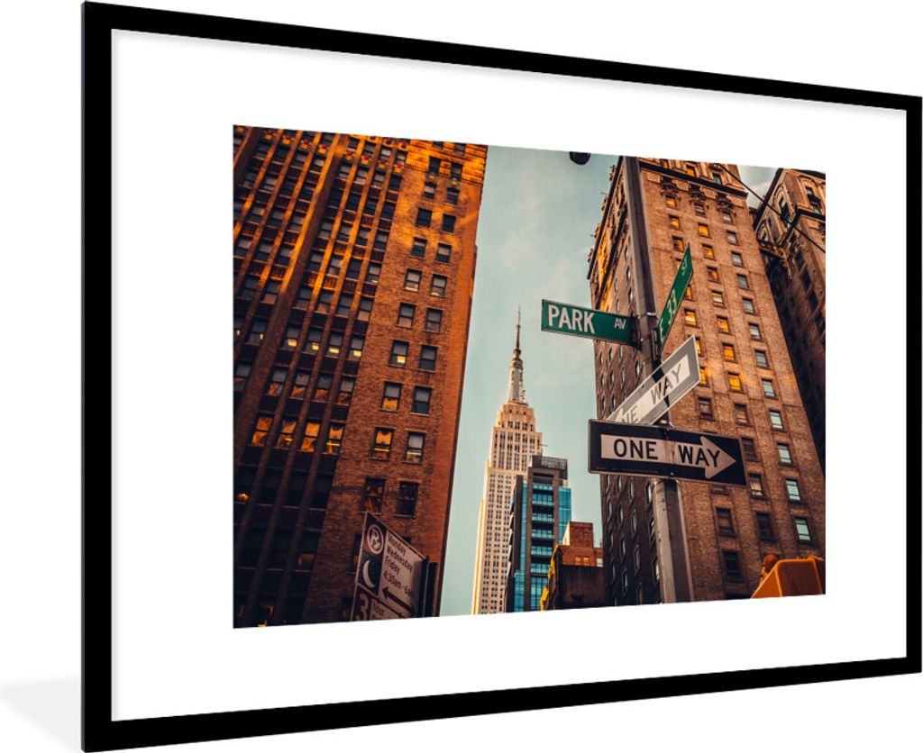 MuchoWow Gerahmtes Poster Das Empire State Building zwischen den hohen Gebäuden in New York 90x60 cm - Poster mit Schwarzem Bilderrahmen Wandpos...