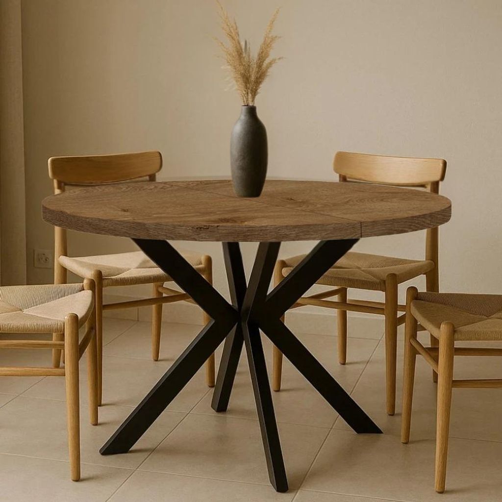 A round dining table with a wooden top and black metal legs, surrounded by four chairs in a dining room setting.