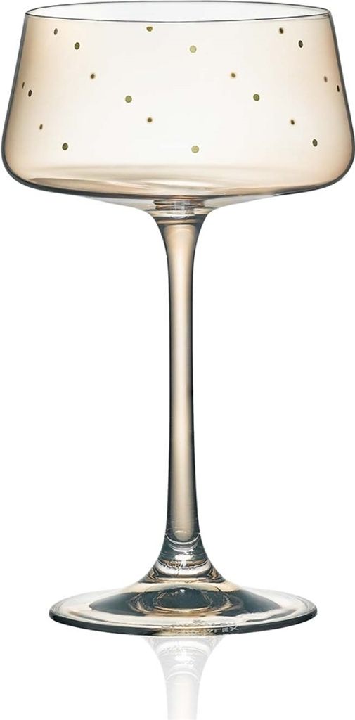 A single champagne coupe glass with gold polka dots.