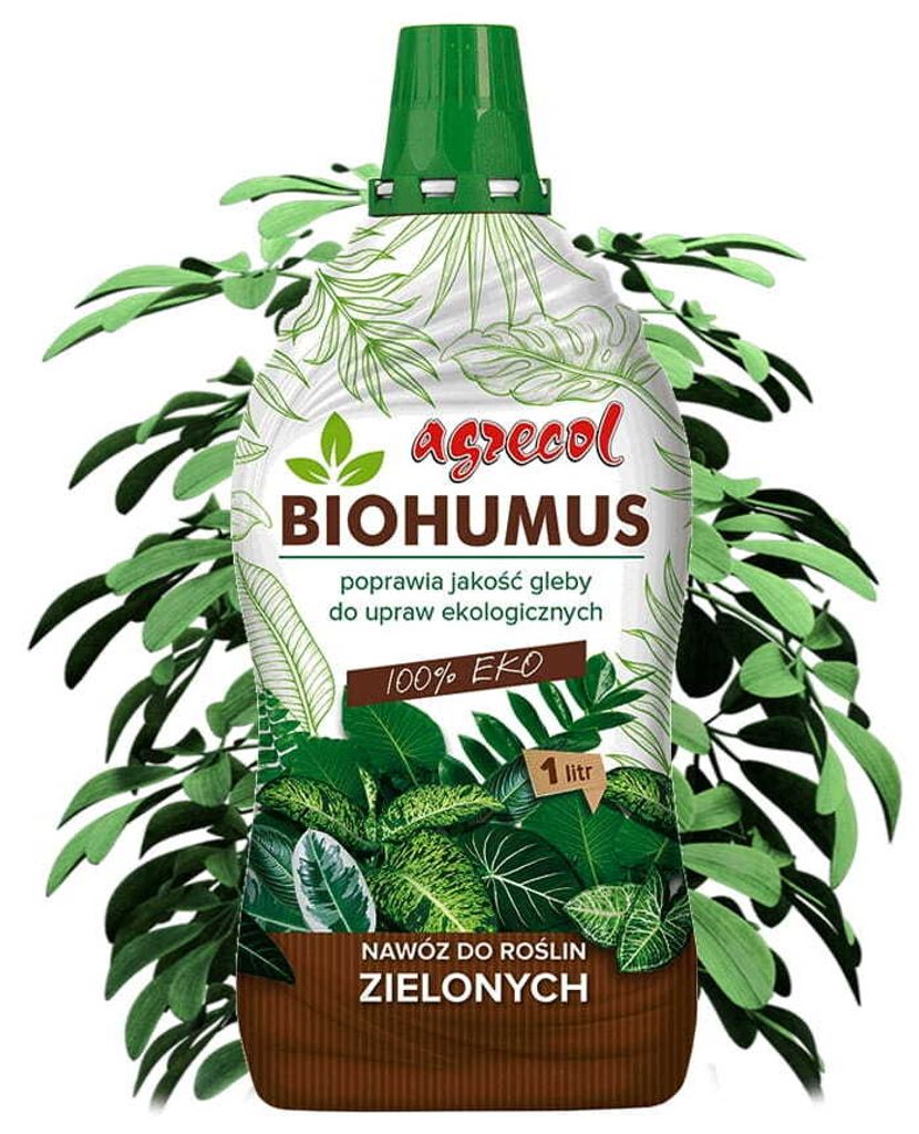 A bottle of Biohumus fertilizer for green plants, surrounded by green leaves.
