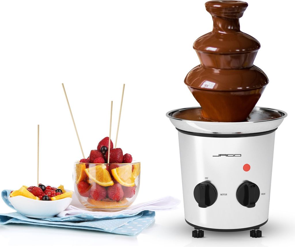 A chocolate fountain with fruit skewers and bowls of fruit, presented on a white background.