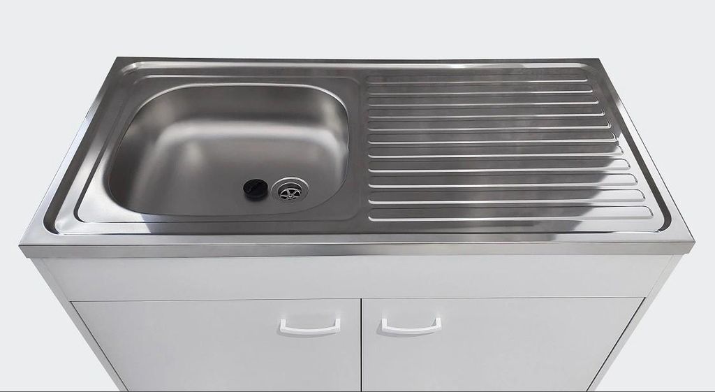 A stainless steel kitchen sink with a draining board is shown mounted on a white cabinet.