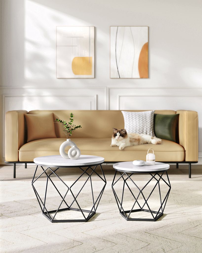 A living room scene with a sofa, coffee tables, and artwork.