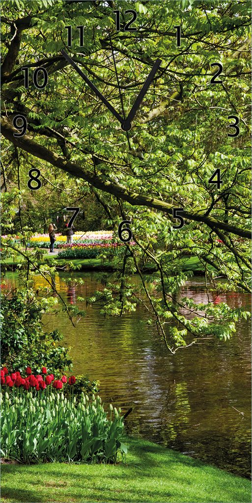 Wallario Design Wanduhr Bunte Blumen im Park am Wasser - Frühblüher am Ufer aus Echtglas, Größe 30 x 60 cm