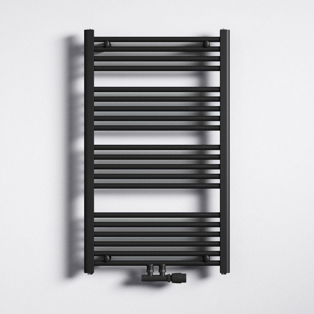 A black radiator is mounted on a white wall.