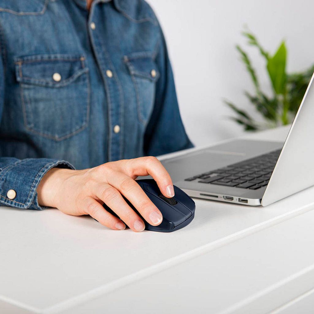 A person's hand is using a dark blue wireless mouse next to a laptop.