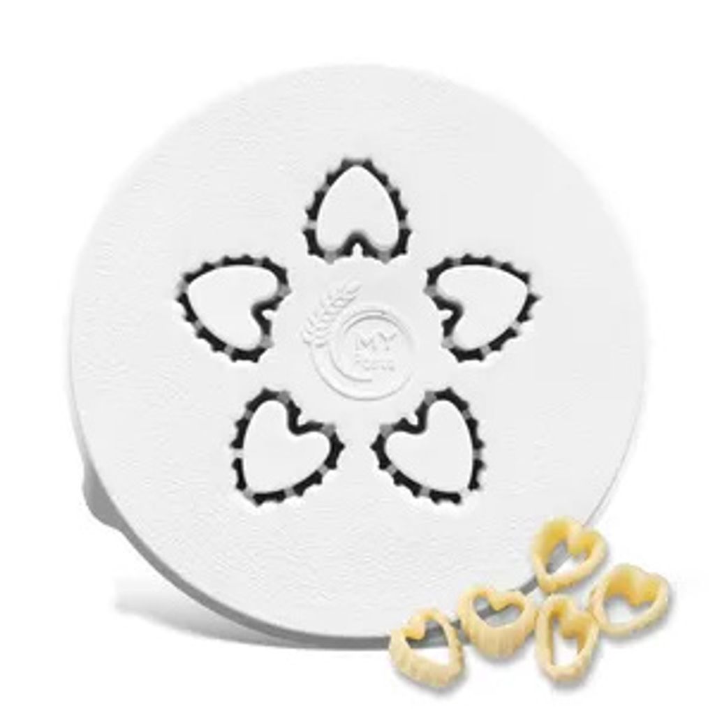 A white pasta cutter with heart-shaped cutouts, shown with a few finished pasta pieces.