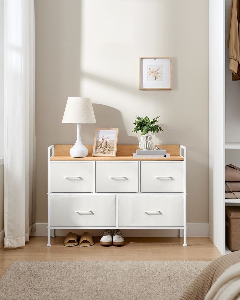 A chest of drawers with clothing items in a closet.