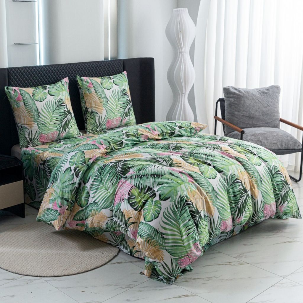A bedroom scene with a bed dressed in tropical-themed bedding.