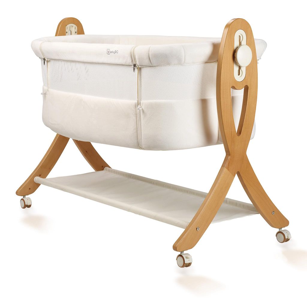 A baby bassinet on a wooden stand with wheels.