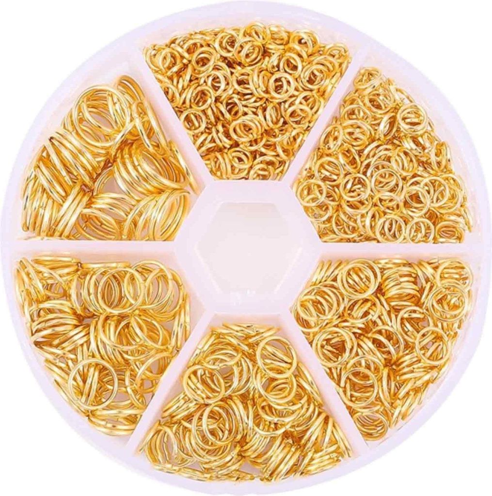 A circular plastic container with six compartments, each filled with gold-colored jump rings for jewelry making.