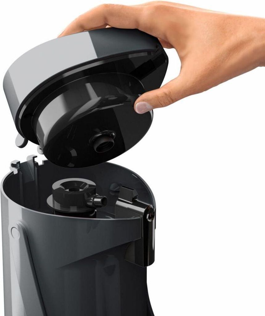 A hand is shown removing the lid from a gray and black appliance.