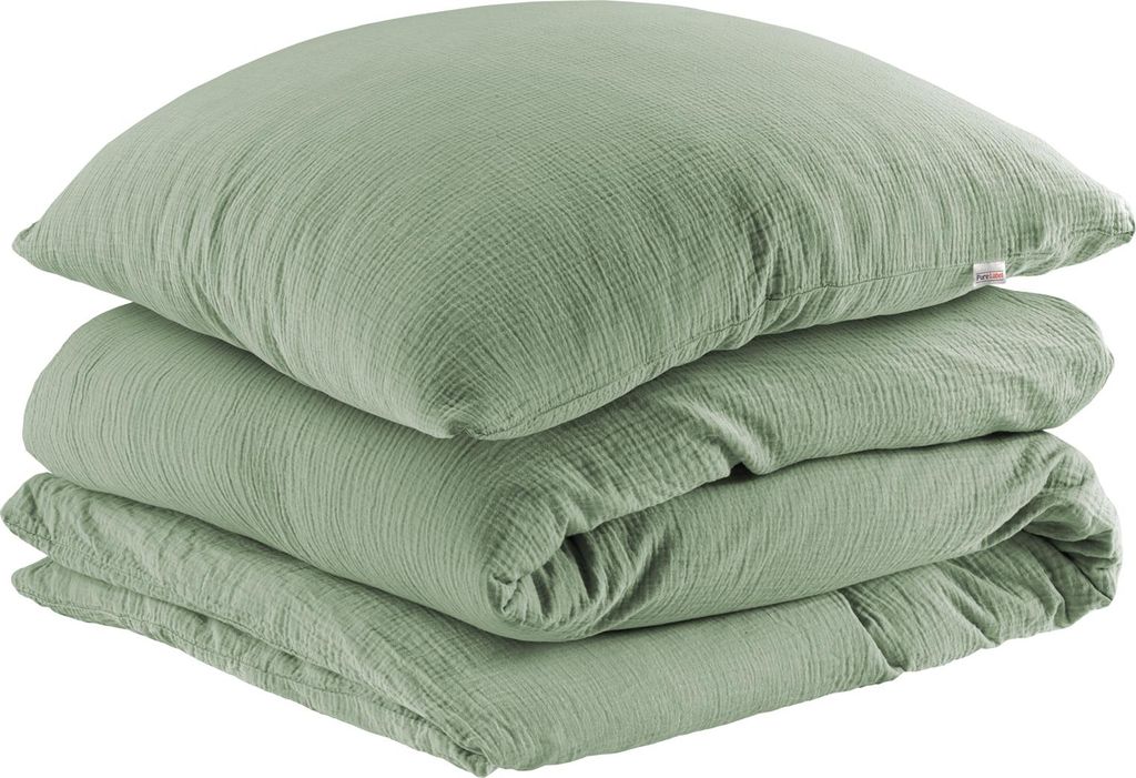 A stack of folded green bedding, including a pillow and a duvet cover, on a white background.