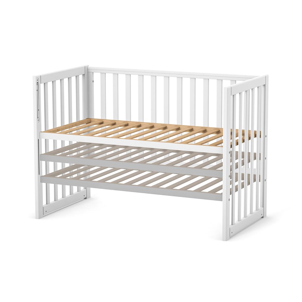 A white baby crib with a wooden slatted base, shown from a slightly elevated side angle against a white background.