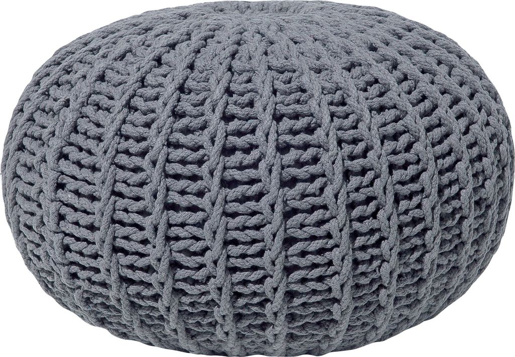 A close-up view of a round, knitted pouf.