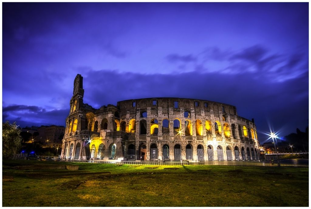 Wallario Premium Glasbild, freischwebende Optik, kräftige Farben, Größe 90 x 60 cm Motiv Italien bei Nacht - Kollosseum in Rom, beleuchtet am Abend