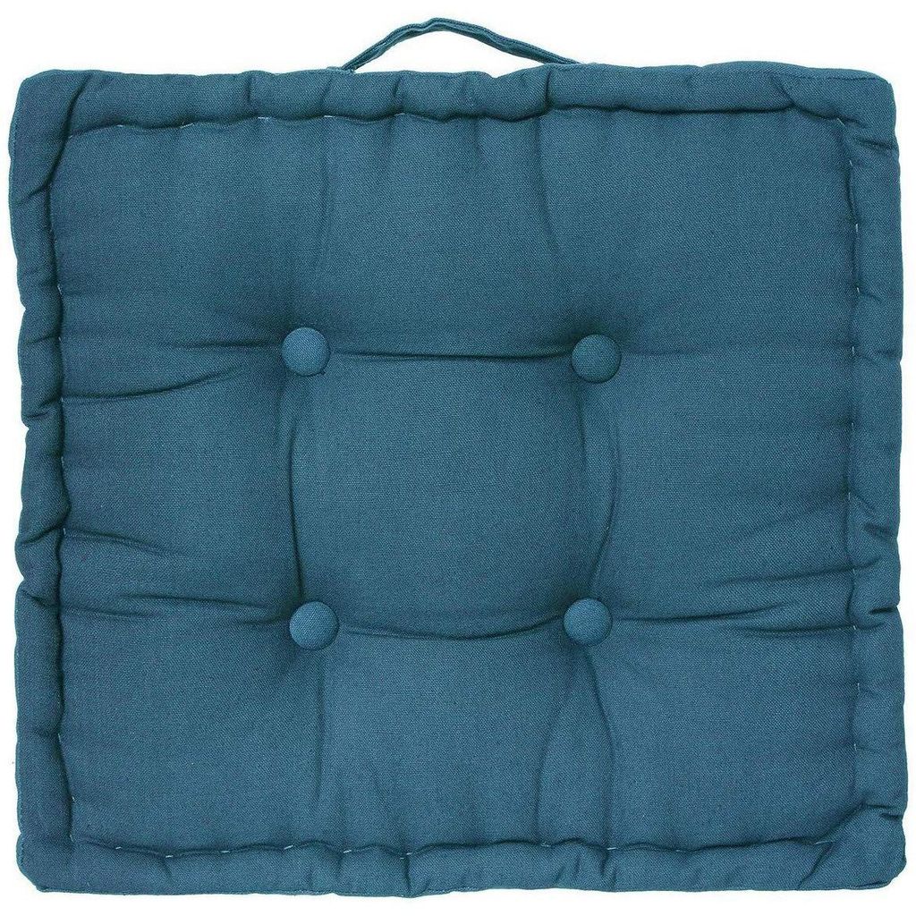 A square teal floor cushion with tufting buttons and a handle on top.