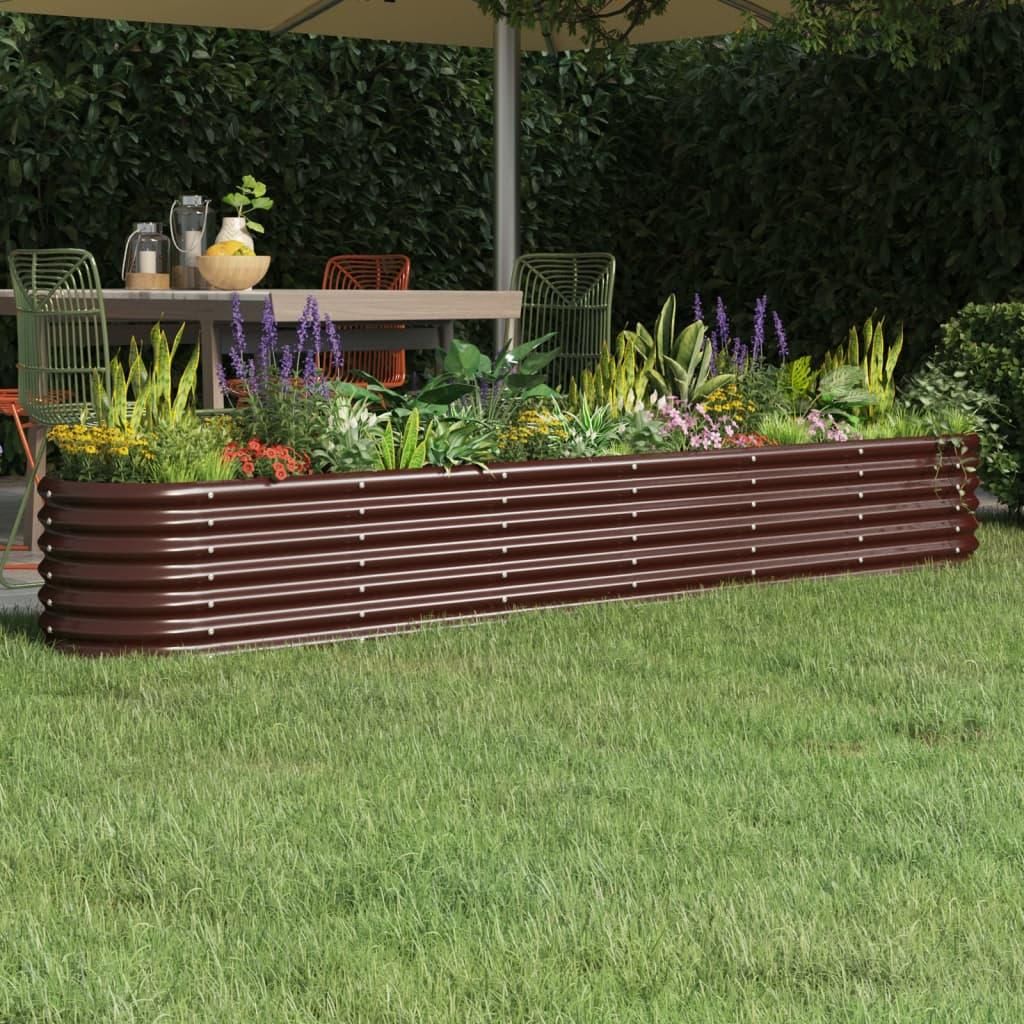 A raised garden bed filled with plants is shown in a backyard setting, with a table and chairs visible in the background.