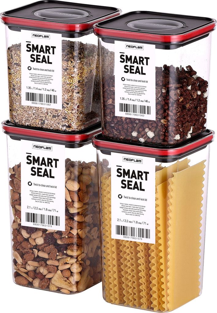 Four clear plastic food storage containers with red and black lids, stacked in a two-by-two arrangement. Each container has a white label with black text.