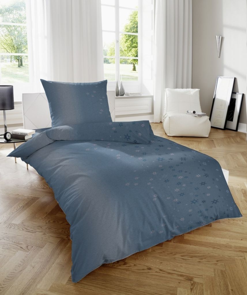 A bedroom scene with a bed made with blue bedding.