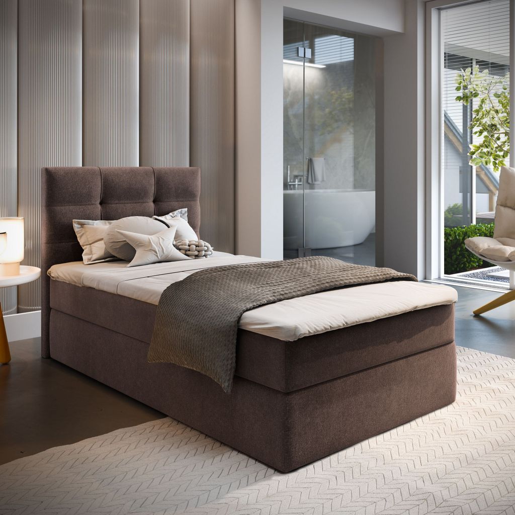 A bedroom scene with a bed, pillows, and a blanket.