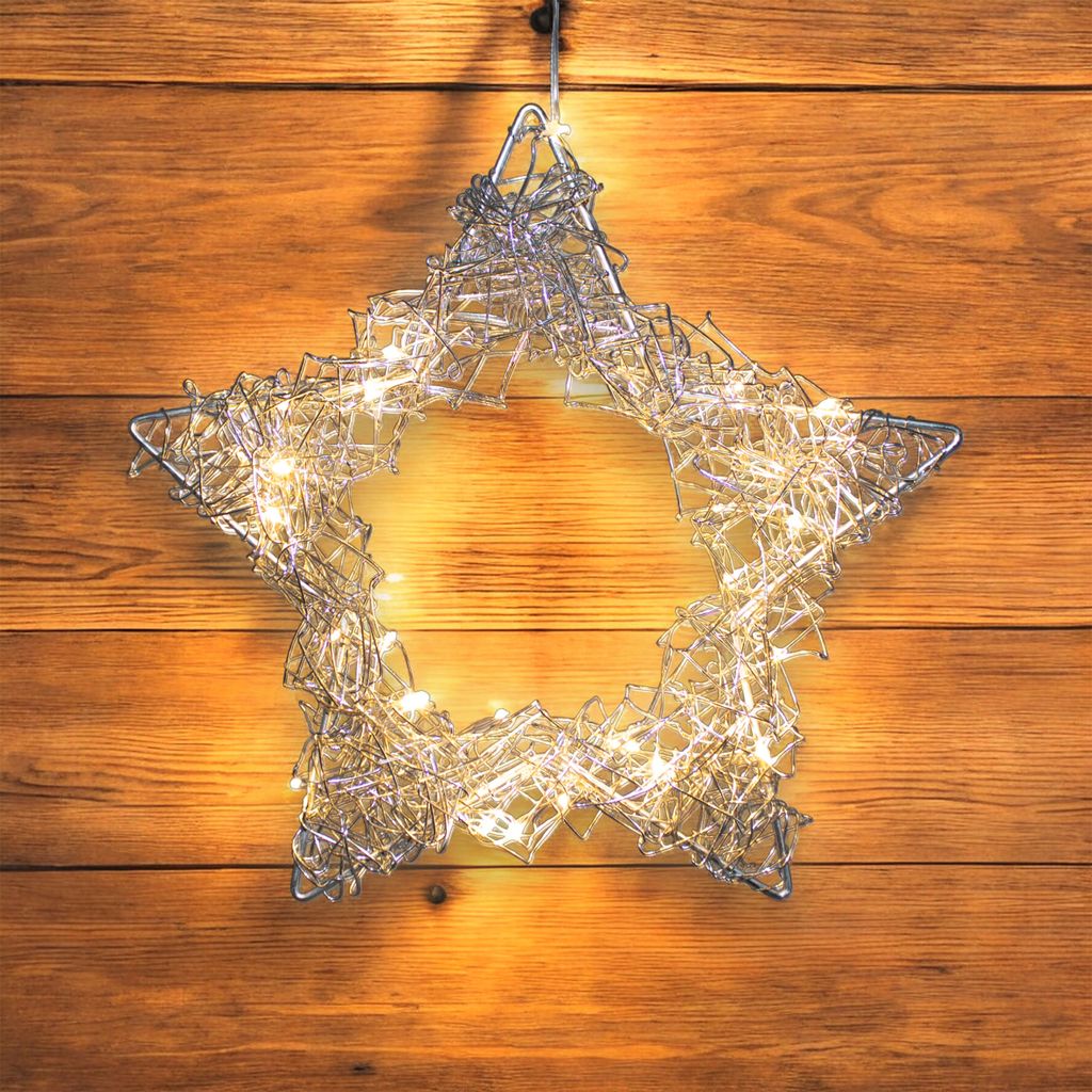 A silver wire star with LED lights hanging on a wooden wall.