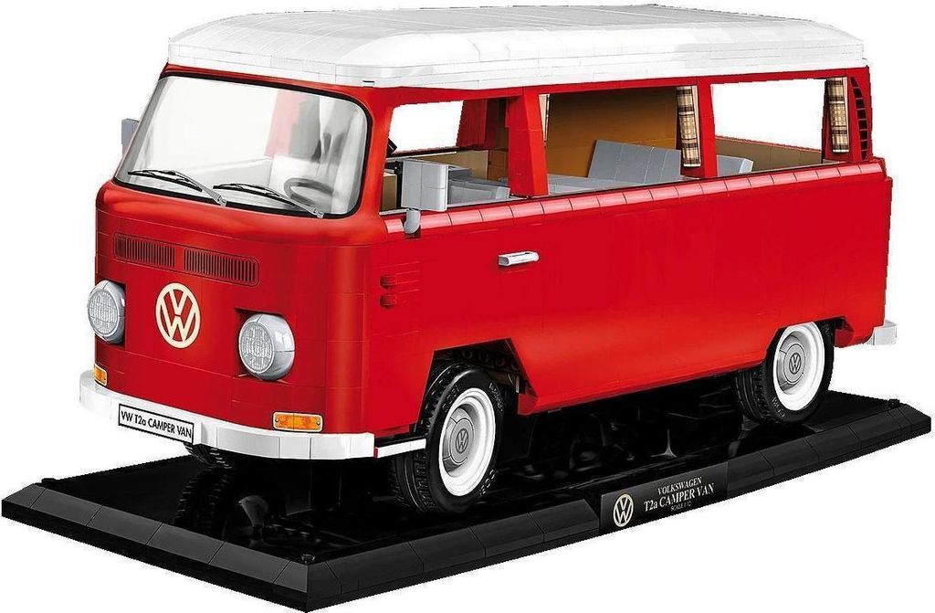 A red and white Volkswagen Transporter T2A camper van model on a black display stand.
