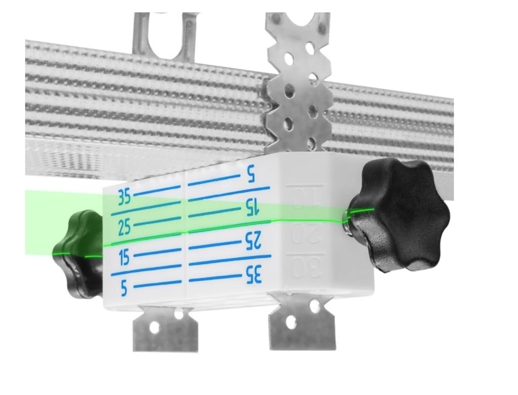 A close-up view of a white leveling device with blue markings and a green laser line, attached to a metal ceiling profile.