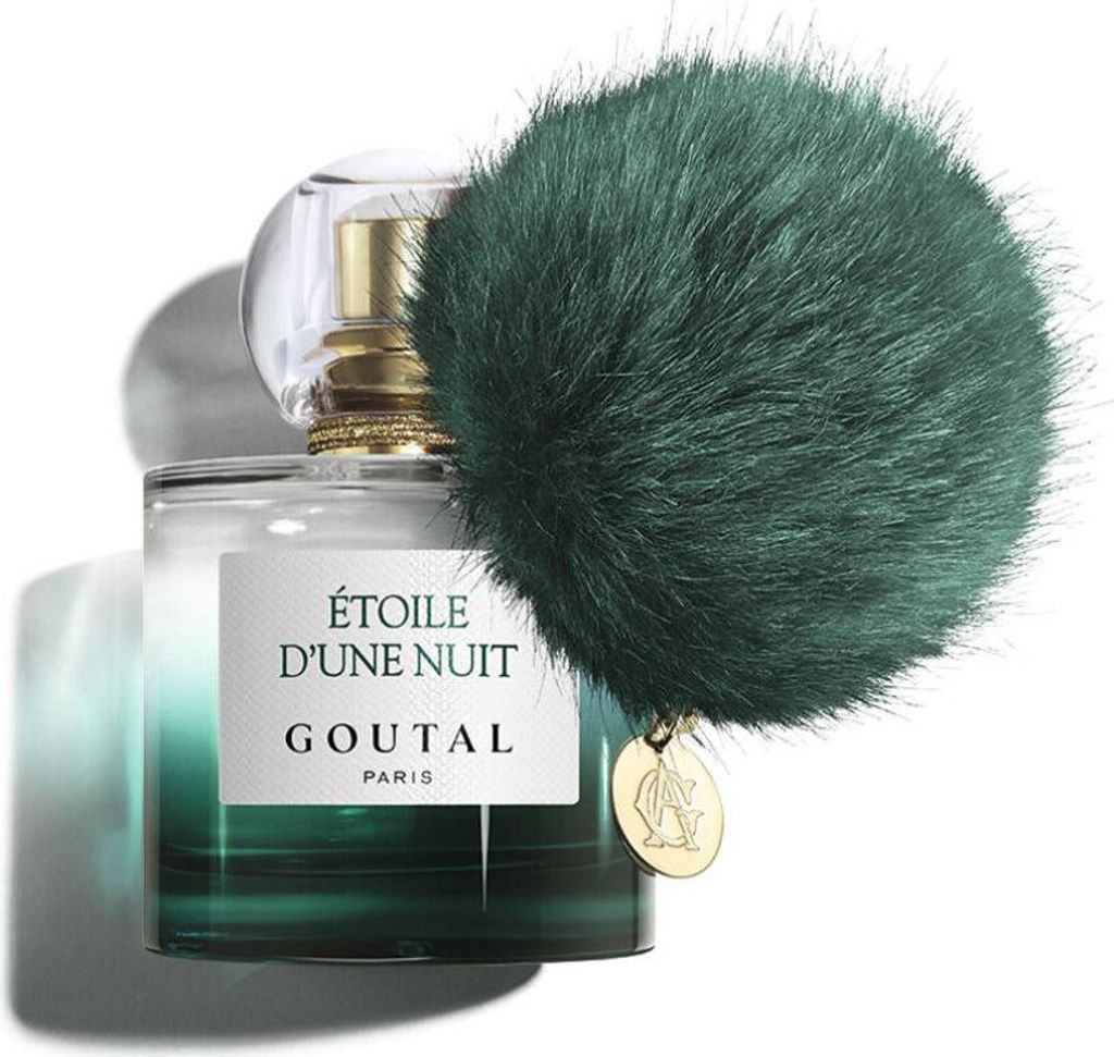 A bottle of Goutal perfume with a green fluffy pom-pom accessory.