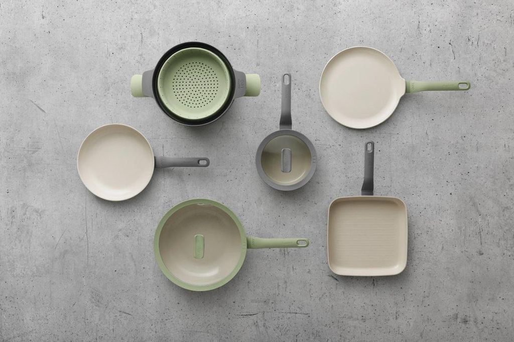 A collection of cookware arranged on a textured gray surface.
