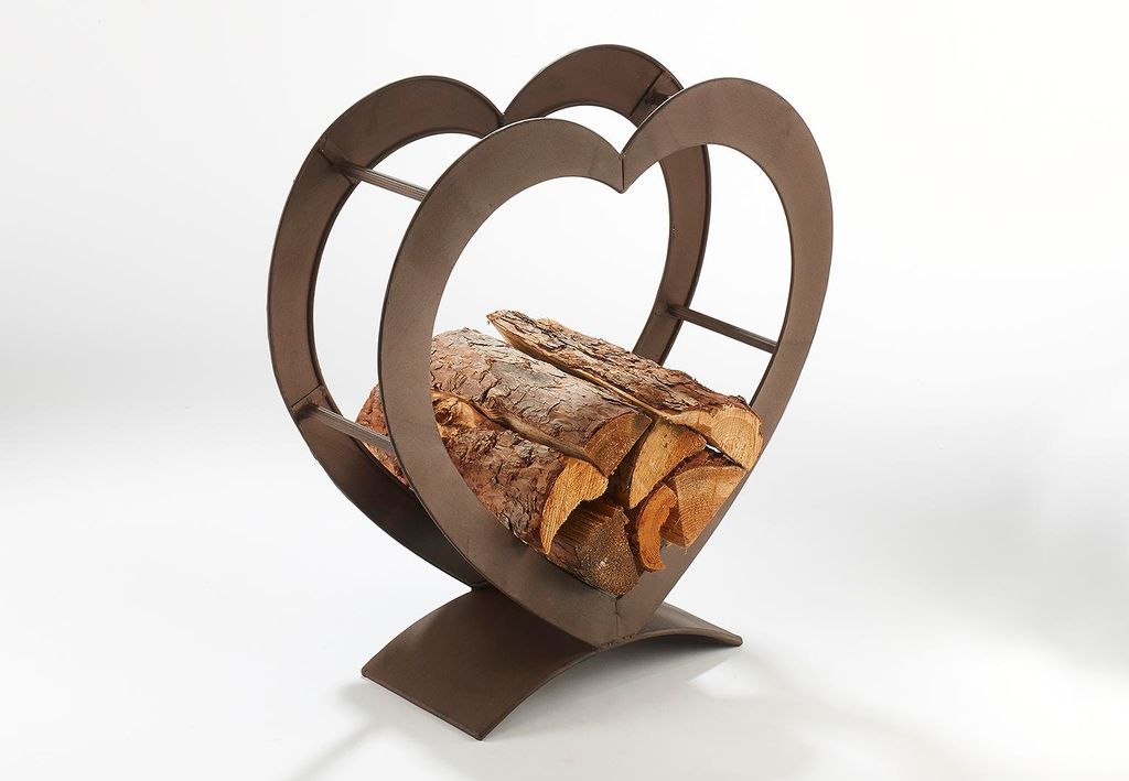 A heart-shaped metal log holder filled with firewood, set against a white background.
