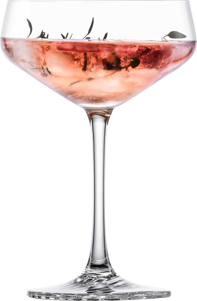 A single cocktail glass filled with a pink beverage and ice, garnished with herbs.