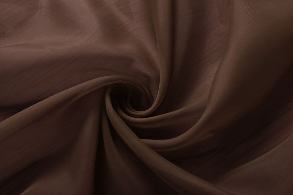 A close-up, swirled view of brown transparent fabric.