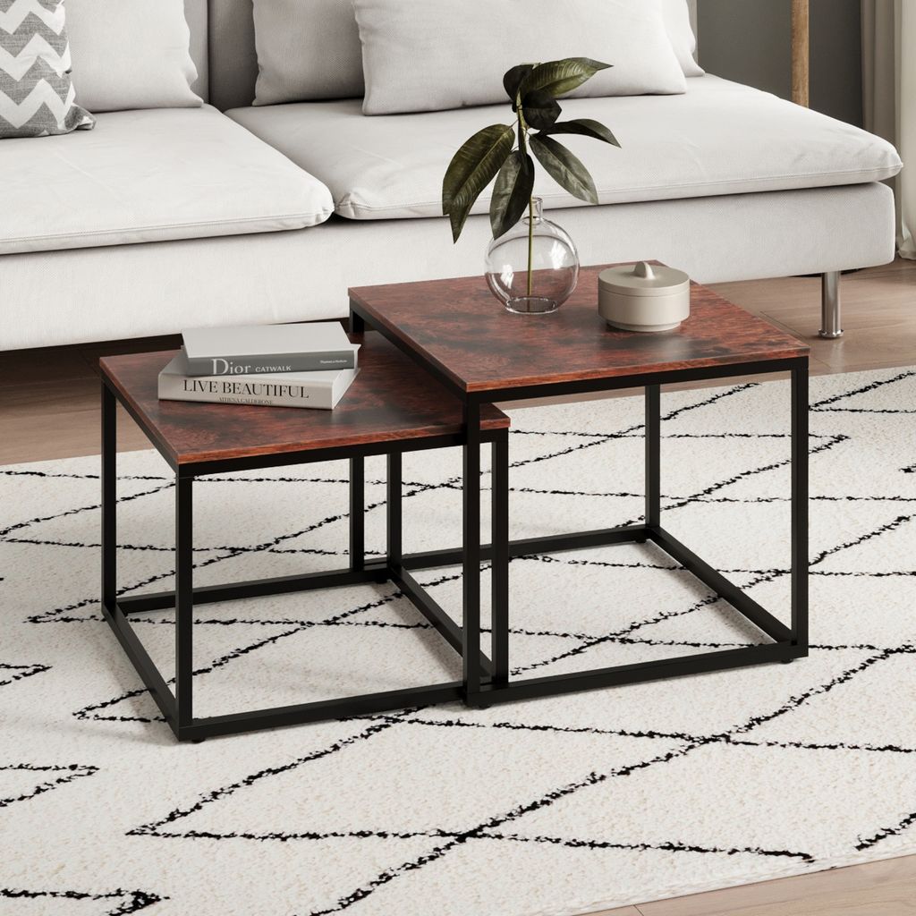 A living room scene with a couch, rug, and nesting coffee tables.