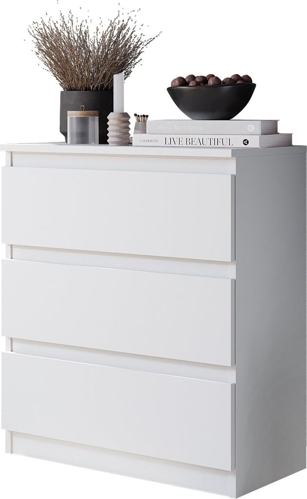 A white three-drawer dresser with decorative items on top.
