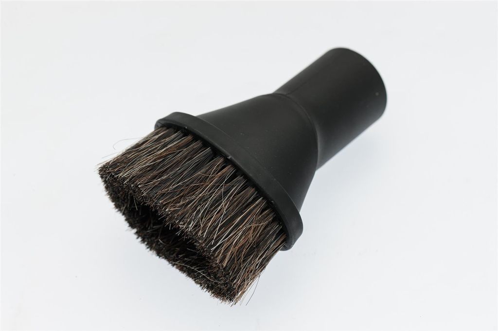 A close-up studio shot of a black vacuum cleaner brush attachment with natural bristles.