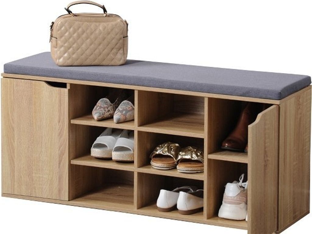 A shoe cabinet with a cushioned top is filled with various shoes and a handbag.